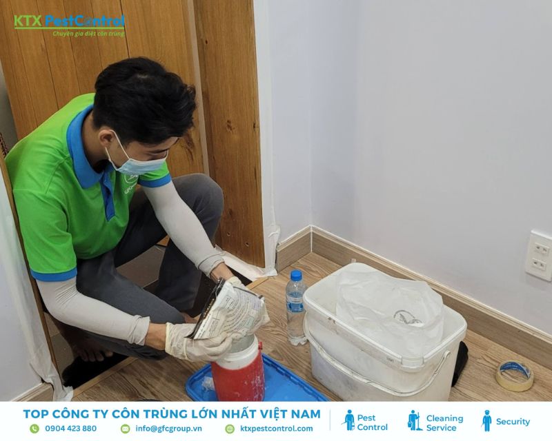 kỹ thuật viên dịch vụ diệt mối Hà Nội rắc thuốc tiêu diệt mối