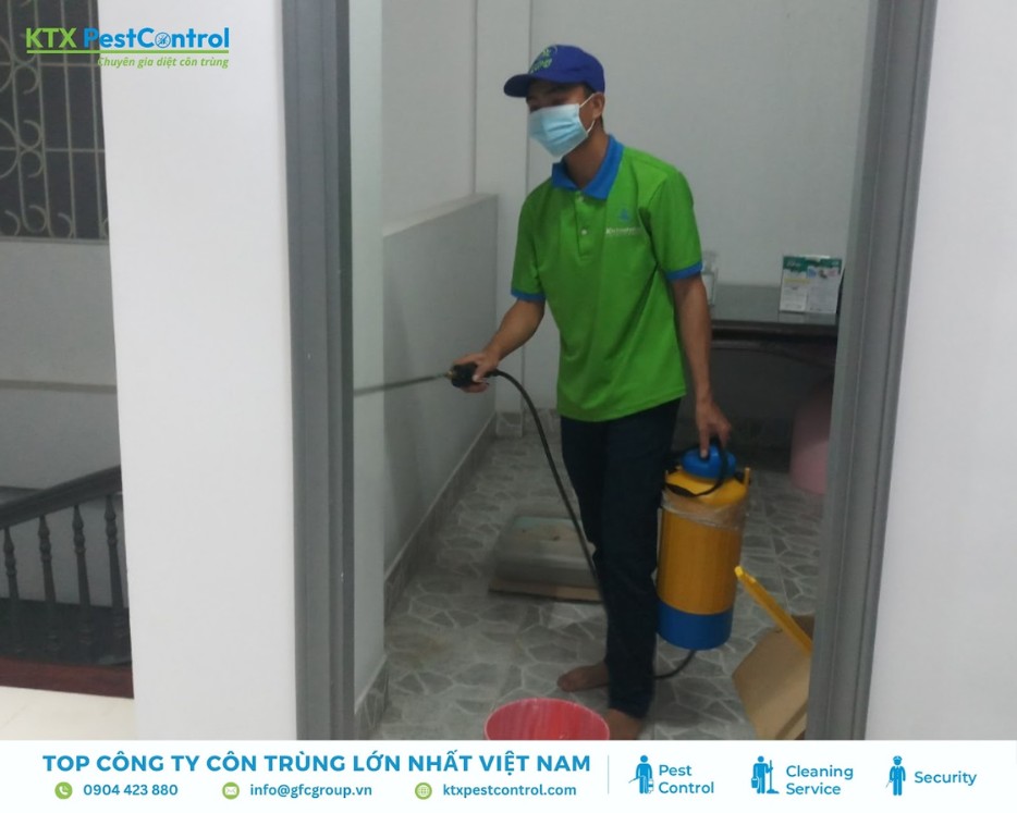 Nhân viên đang thực hiện dịch vụ diệt mối quận Hai Bà Trưng bằng bình phun chuyên dụng
